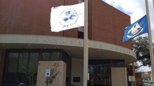 The front of the LPL main branch on Congress street in Lafayette. The library flag as well as the Louisiana state flag are visible flying.